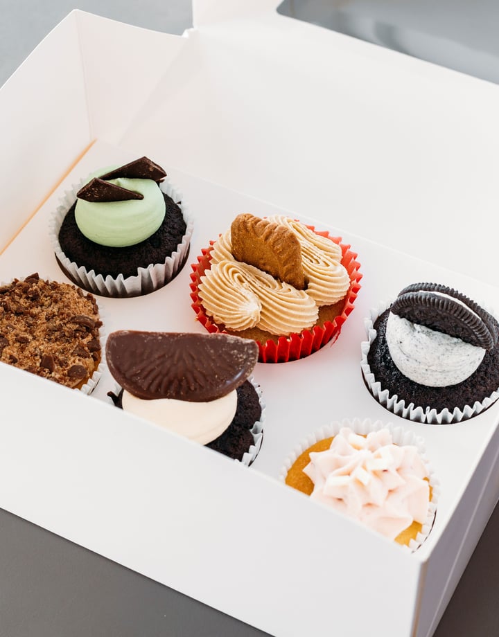 Colourful cupcakes in a white box.