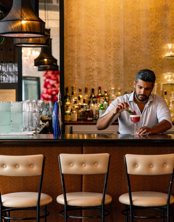 A man making a cocktail at a bar.