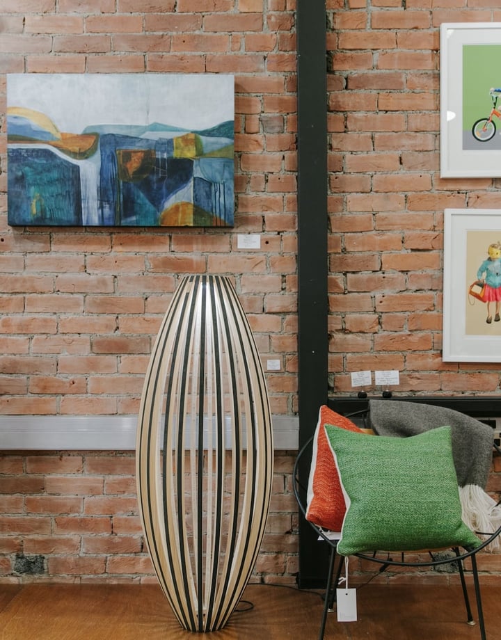 Interior view of art hanging on a brick wall at 77 Art + Living.