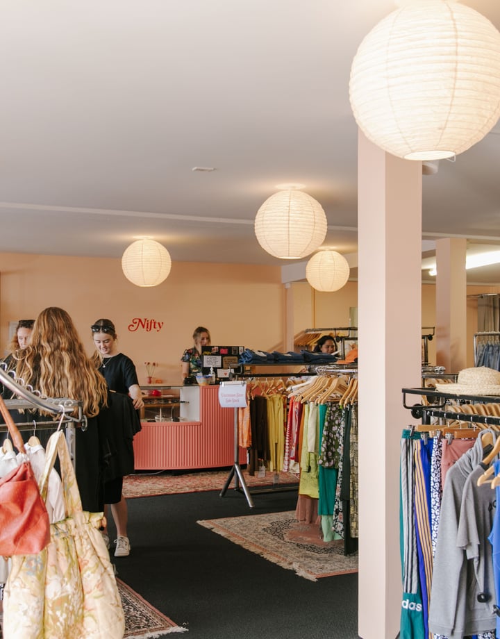 The busy and bright interior of a second hand clothing store.