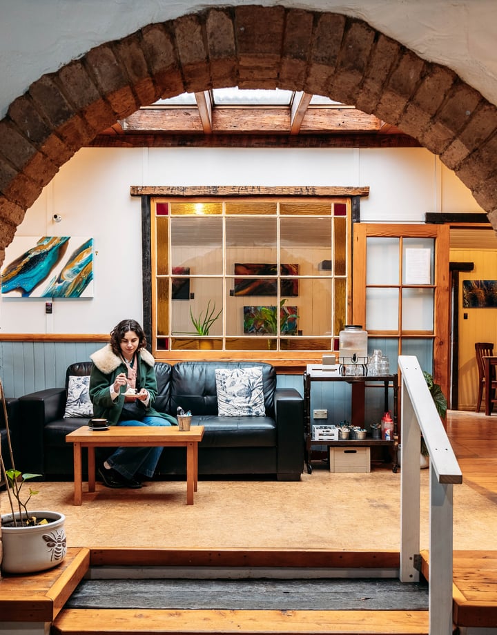 A woman sitting on a couch in a cafe.