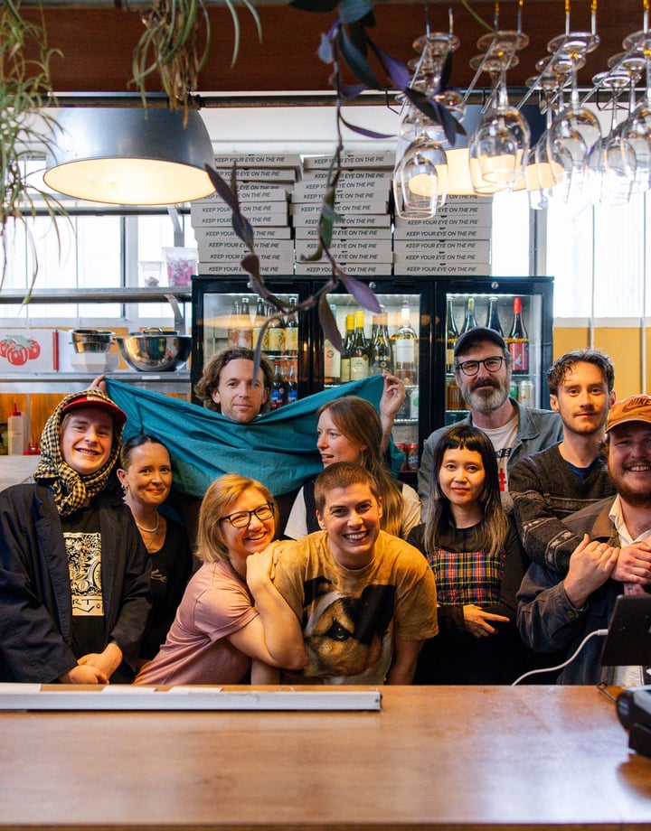 A group of people posing for the camera behind a bar.