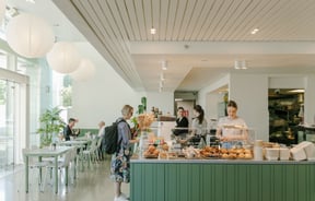 A customer ordering at the white and green counter at Doubles cafe Christchurch.