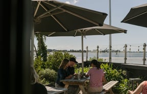 People sitting outside near the estuary on a sunny day.