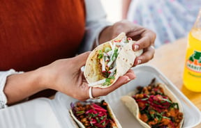 Close up of a person's hands holding a taco.