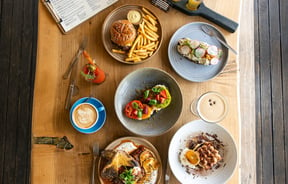 Flat-lay of a table of sweet and savoury dishes and coffee and cocktails at Okere Falls Store.