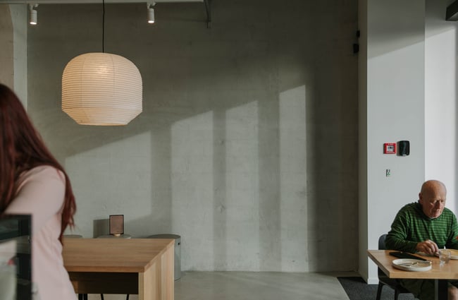 Concrete walls and floor inside a brightly lit cafe.
