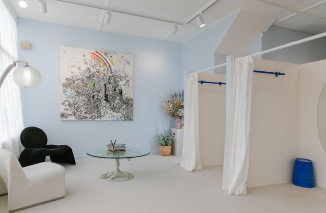 The dressing rooms with white curtains and a blue feature wall.