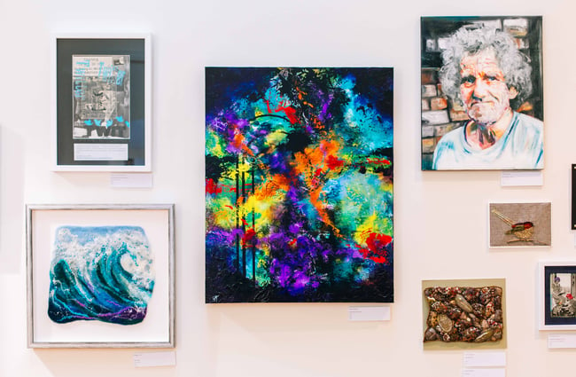 Bright colourful artworks hanging on the wall.