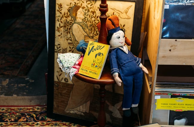 Close up of an old book and doll on the floor.