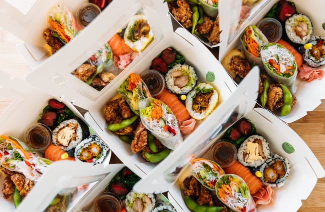 A birdseye view of boxes of delicious looking sushi.