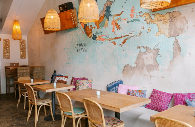 Seating area with bench seats and colourful cushions at Bandung Café, Auckland.