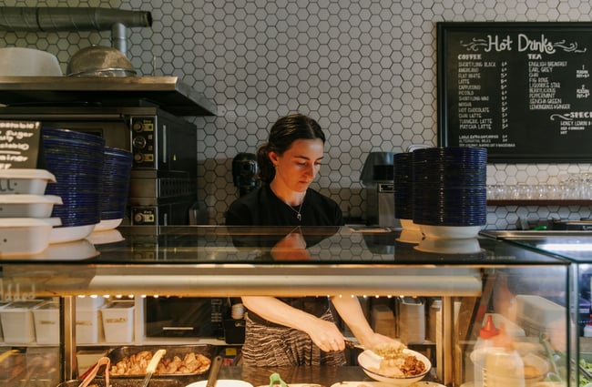 A staff member putting together a plate of food behind the counter at Big Fig in Wānaka.