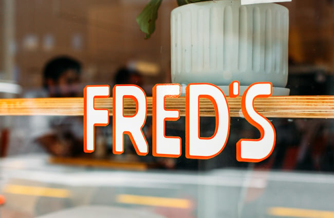 Exterior window sign for Fred's, Wellington.