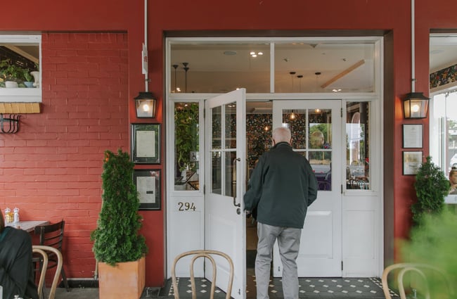 An elderly man walks into Little Poms café, Christchurch.