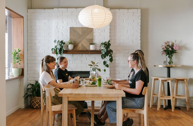 Four women chatting and smiling around a table at Mint Folk and Co in Twizel.