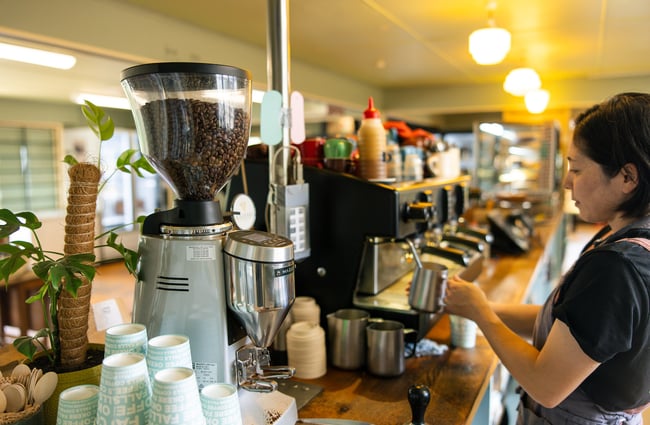 A barista making coffee at Okere Falls Store.