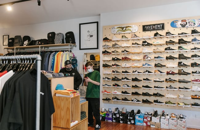 Interior view of Pavement with a wall of sneakers on display.