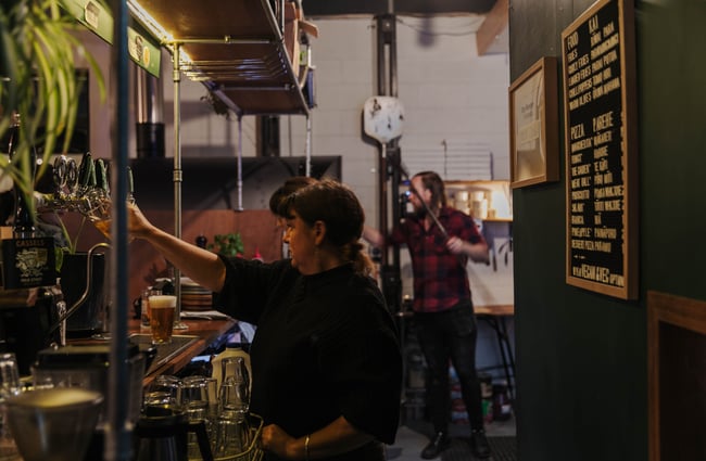 Woman pouring a beer from the tap.