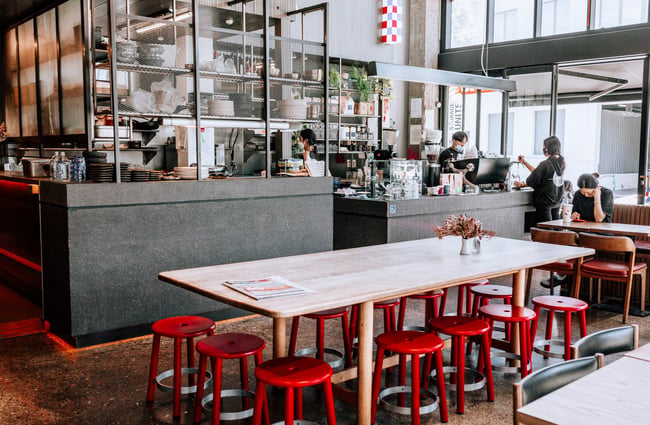 Big communal table with red stools at Simon and Lee, Auckland.