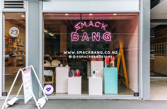 The exterior of the Smack Bang dog store with a neon pink Smack Bang sign.
