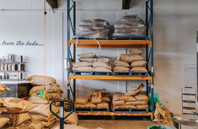 Bags of coffee beans stacked on shelves at Sublime Roastery and Brew Bar.