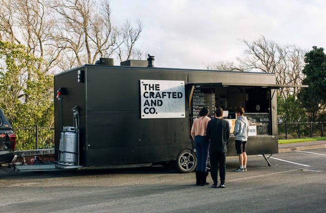 The black food truck with a white and black label.