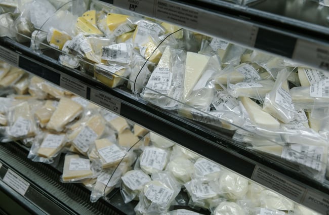Fridge shelves of vacuum-wrapped European cheeses at The Mediterranean Food Company, Christchurch.