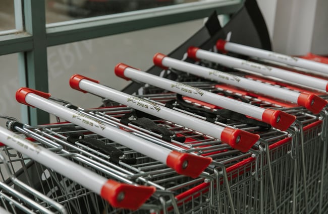 A neatly stacked row of shopping trolleys with The Mediterranean Food Company logo printed on the handles.