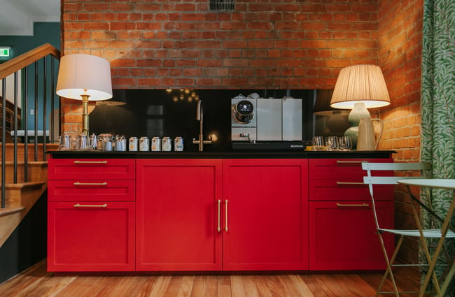 Small Red kitchenette with espresso machine.