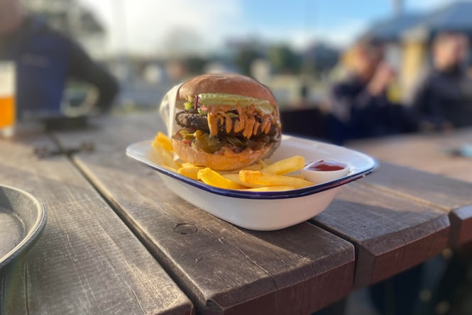A burger on an outdoor table.