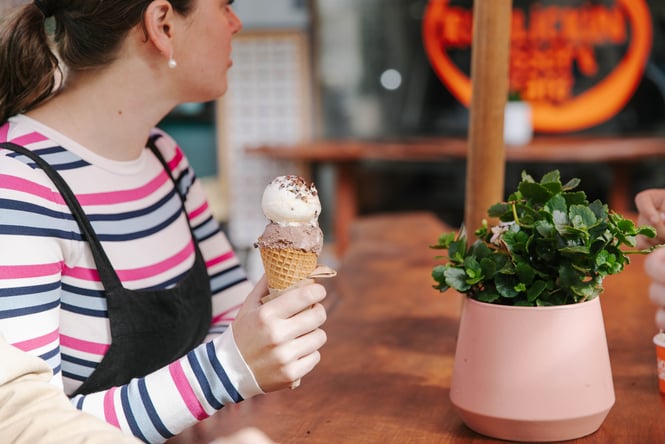 A woman holding a gelato cone.