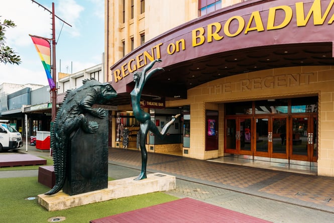 A sculpture of a lizard and a lady dancing outside the Regent on Broadway.