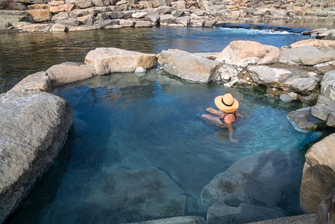 A woman sitting in a hot pool.
