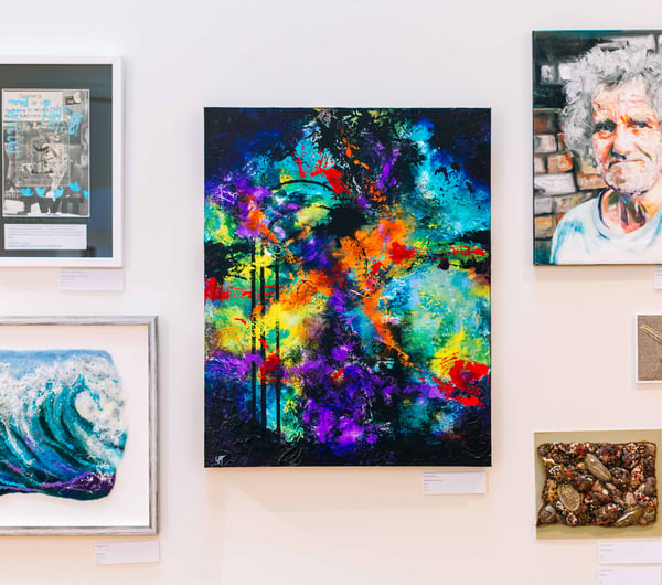 Bright colourful artworks hanging on the wall.