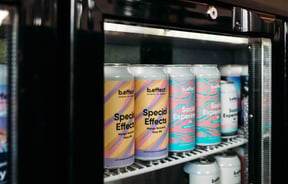 Close up of pastel-coloured labels on b.effect's beer cans in the fridge.