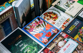 Close up of cookbooks on a table.