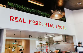 Real food real local signage above counter.