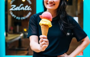 Woman holding ice cream on cone.