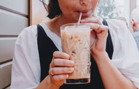 Women sipping on an iced coffee at a cafe