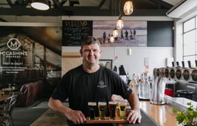 Man holding beer flight from McCashin's.