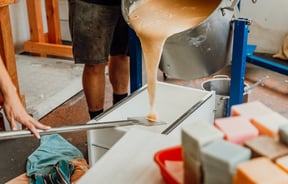 Liquid soap being poured on to a table ready for setting.