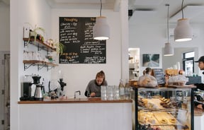 Woman standing underneath blackboard menu at Bobby Franks.