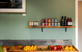 Sauces for sale on a shelf above fresh fruit bins at General Post, Christchurch.