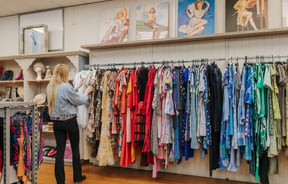 A woman browsing the colourful vintage clothing at Godzilla in Nelson.