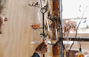 A woman sitting next to three glasses of wine inside Rimu Wine Bar in Mapua.