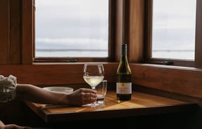 Woman holding a glass of white wine at Boat Shed Cafe.