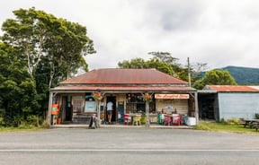 An old looking building with products positioned out front.