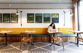 A customer sitting at a table inside a brightly coloured restaurant.