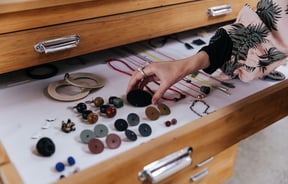 Someone looking at unique jewellery pieces on display.